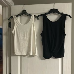 Lot of 2 workout tanks from Born Primitive (cream) and Athleta (black) in size M